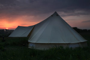 Sunset behind a bell tent at Pete's Field campsite in Kent