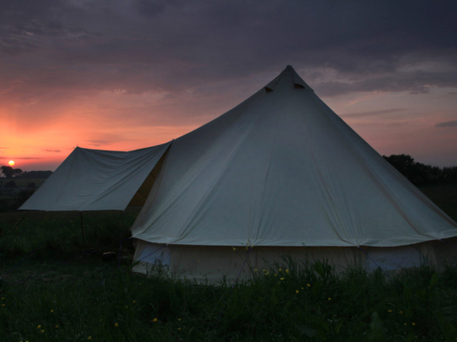 A bell tent at Pete's Field campsite at sunset