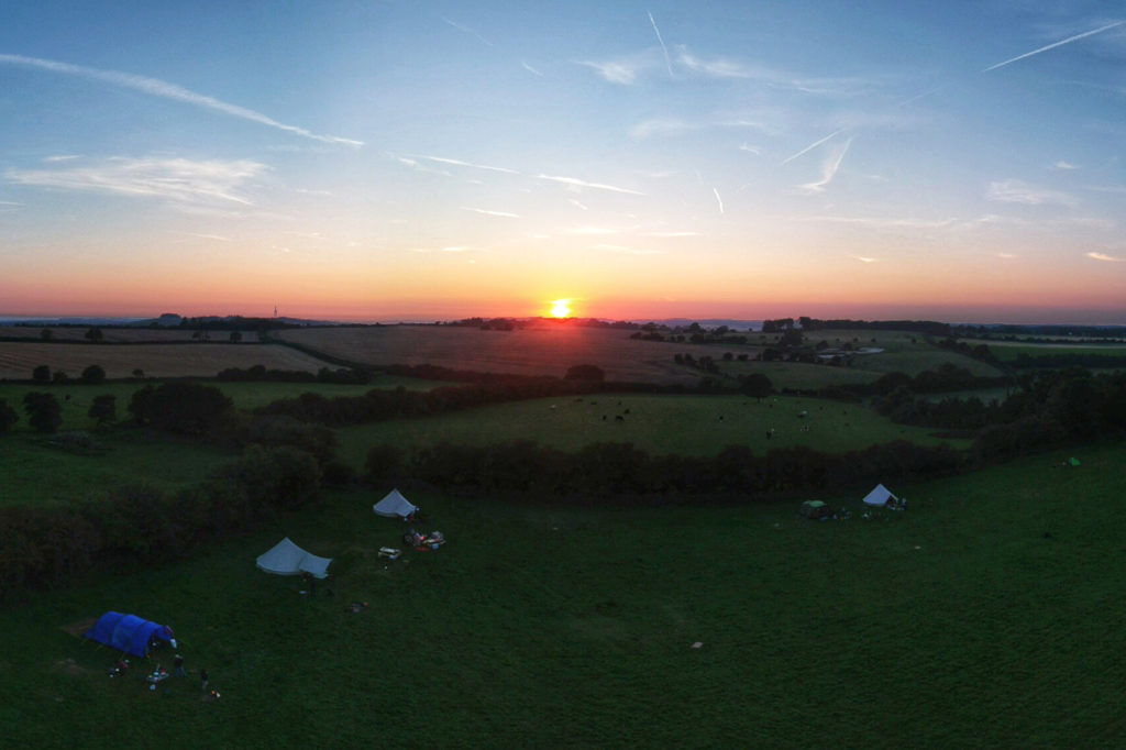 Back-to-basics camping in the Kent Downs viewed from above at sunset